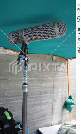 Microphone boom type. Sound recorder boom mic and tripod stand. Professional digital audio recording gear mic for making film or video movie production. Wind protection on boom mic. Movie industry Microphone boom type. Sound recorder boom mic and tripod stand. Professional digital audio recording gear mic for making film or video movie production. Wind protection on boom mic. Movie industry 82592368