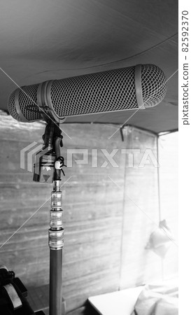 Microphone boom type. Sound recorder boom mic and tripod stand. Professional digital audio recording gear mic for making film or video movie production. Wind protection on boom mic. Movie industry Microphone boom type. Sound recorder boom mic and tripod stand. Professional digital audio recording gear mic for making film or video movie production. Wind protection on boom mic. Movie industry 82592370