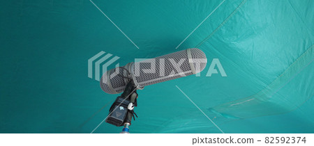 Microphone boom type. Sound recorder boom mic and tripod stand. Professional digital audio recording gear mic for making film or video movie production. Wind protection on boom mic. Movie industry Microphone boom type. Sound recorder boom mic and tripod stand. Professional digital audio recording gear mic for making film or video movie production. Wind protection on boom mic. Movie industry 82592374