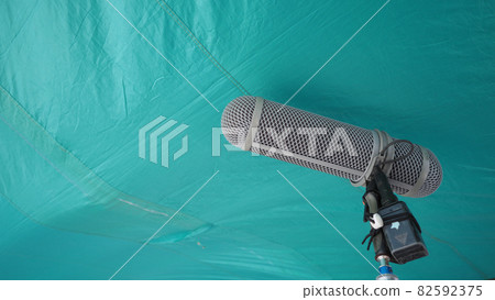 Microphone boom type. Sound recorder boom mic and tripod stand. Professional digital audio recording gear mic for making film or video movie production. Wind protection on boom mic. Movie industry Microphone boom type. Sound recorder boom mic and tripod stand. Professional digital audio recording gear mic for making film or video movie production. Wind protection on boom mic. Movie industry 82592375
