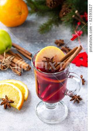 Christmas mulled wine, winter alcoholic drink. A glass of mulled wine (gluhwein) and its ingredients on a stone background. Christmas mulled wine, winter alcoholic drink. A glass of mulled wine (gluhwein) and its ingredients on a stone background. 82593827