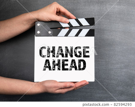 Change Ahead. White movie clapper in woman hand on chalkboard background 82594293