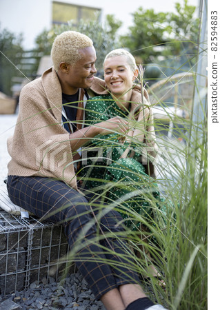 Man hugging his european girlfriend in garden 82594883