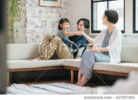 Family relaxing in the living room at home Family relaxing in the living room at home 82595360