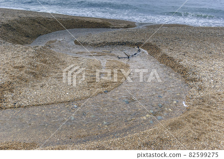 Fresh water stream going into the sea with visible sun rays - Cornwall, United Kingdom Fresh water stream going into the sea with visible sun rays - Cornwall, United Kingdom 82599275