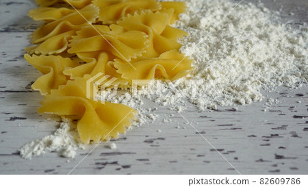 Wheat and farfalle as ingredients for pasta 82609786