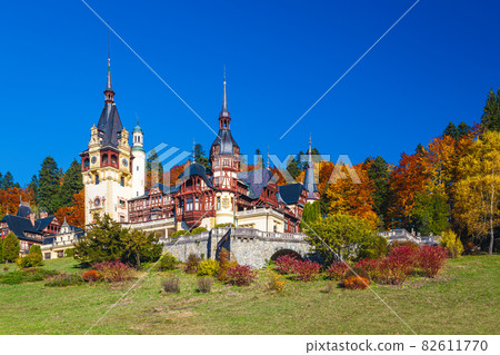 Colorful autumn forest and Peles castle with ornamental garden, Romania Colorful autumn forest and Peles castle with ornamental garden, Romania 82611770