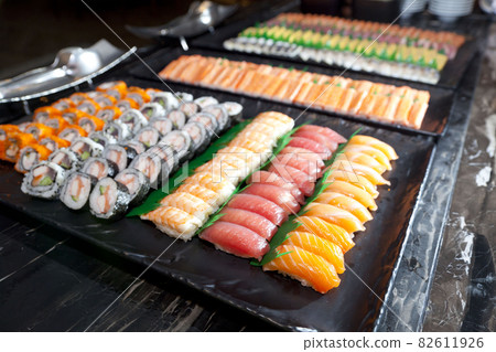 A lot of sushi rolls and maki on the buffet line. Japan traditional food. 82611926