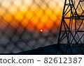 Sunrise burning red through the wire mesh 82612387