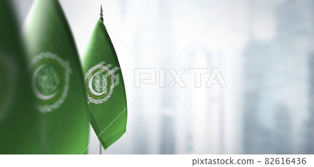 Small flags of Arab League on a blurry background of the city 82616436