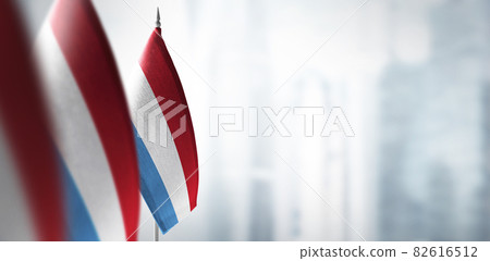 Small flags of Luxembourg on a blurry background of the city Small flags of Luxembourg on a blurry background of the city 82616512