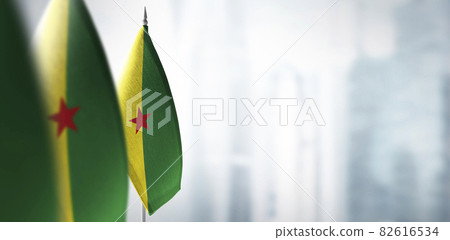 Small flags of French Guiana on a blurry background of the city 82616534
