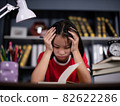 girl school student feeling headache or fatigue doing homework at home. Exhausted depressed sick teenager studying alone worried about difficult education problems concept. 82622286