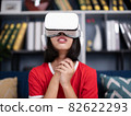 asian girl wearing virtual reality googles at home, remote education experiment, future today, new online education, indoor lifestyle. 82622293