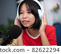 Little Asian girl singing a song in home recording studio. 82622294