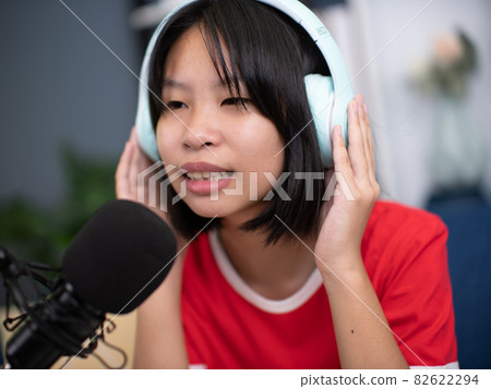 Little Asian girl singing a song in home recording studio. Little Asian girl singing a song in home recording studio. 82622294