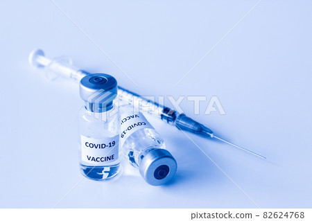Vial of Covid-19 vaccine and 1 ml plastic syringe with needle isolated on the white background 82624768