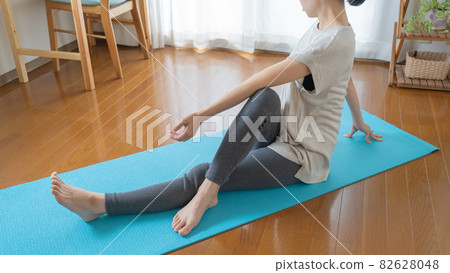 Woman doing yoga and stretching at home | Twisting pose Woman doing yoga and stretching at home | Twisting pose 82628048