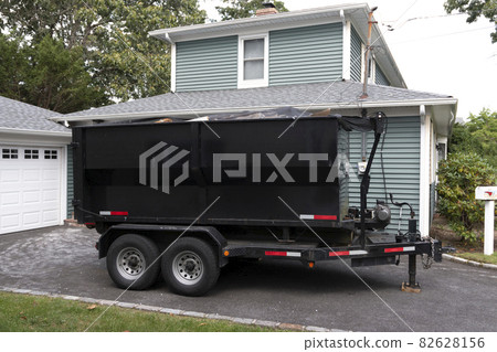 Dumpster on a trailer in a residential driveway Dumpster on a trailer in a residential driveway 82628156