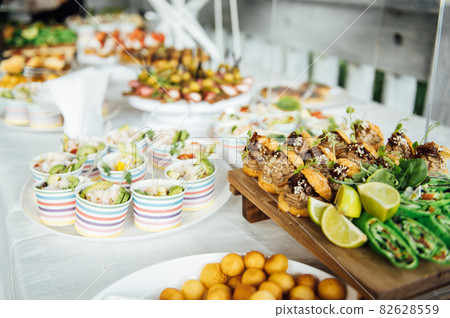 Buffet table of reception with cold snacks, meat and salads Buffet table of reception with cold snacks, meat and salads 82628559