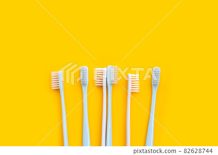 Toothbrushes on yellow background. Top view 82628744