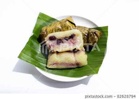 Bundled boiled rice on green leaf on white Bundled boiled rice on green leaf on white 82628794