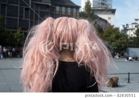 Portrait on back view sexy girl wearing a manga costume with pink wig in the street Portrait on back view sexy girl wearing a manga costume with pink wig in the street 82630551