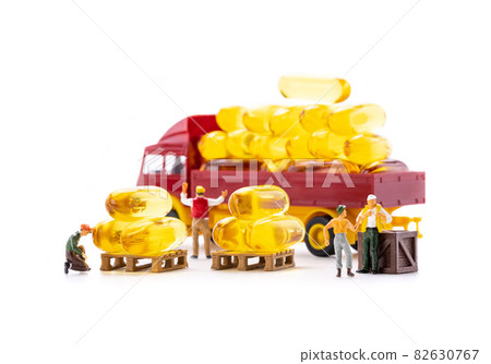 Miniature people workers transportation fish oil supplement capsules by truck isolate on white background 82630767