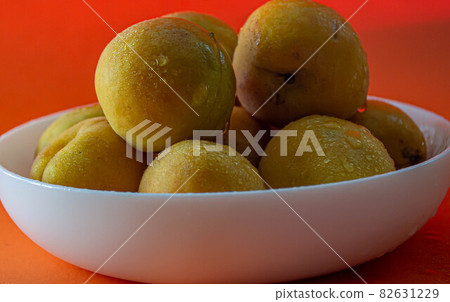 Apricot. Ripe organic apricots on an orange background. Ukraine july 2021 Apricot. Ripe organic apricots on an orange background. Ukraine july 2021 82631229