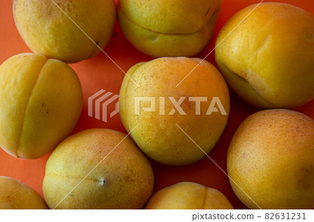Apricot. Ripe organic apricots on an orange background. Ukraine july 2021 Apricot. Ripe organic apricots on an orange background. Ukraine july 2021 82631231