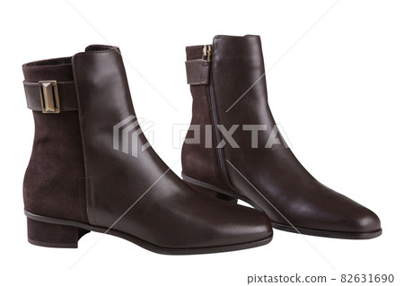 stylish brown ankle boots made of leather and suede, with a buckle, on a white background stylish brown ankle boots made of leather and suede, with a buckle, on a white background 82631690