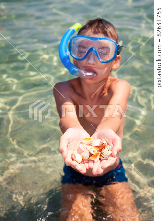 Kid showing shells 82631755