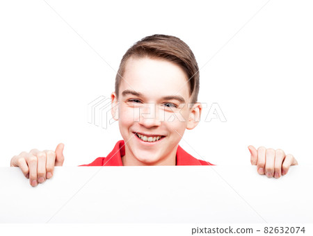 Teen boy holding blank banner or board on white smiling Teen boy holding blank banner or board on white smiling 82632074