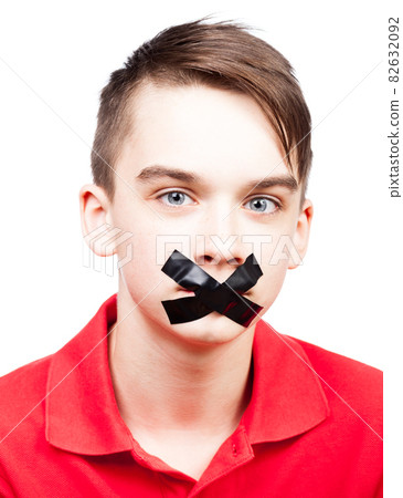 Speechless teen boy with tape over his mouth Speechless teen boy with tape over his mouth 82632092