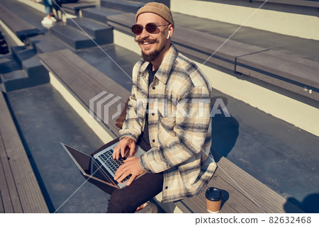 Happy hipster blogger in stylish eyewear types content text for attract new followers to own website Happy hipster blogger in stylish eyewear types content text for attract new followers to own website 82632468