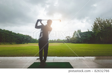 Male golf player driving in golf course. Golfer with golf club taking a shot. 82632766