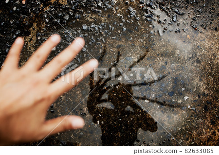Conceptual Photo. Hello Stranger Concept. Photogrpaher taking Self Portrait by Shadow on the Ground. Strange Creepy Hand Reflects on the Floor. Top View 82633085