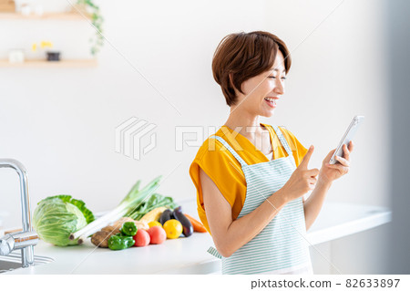 站立在廚房裡的微笑的中部婦女 82633897