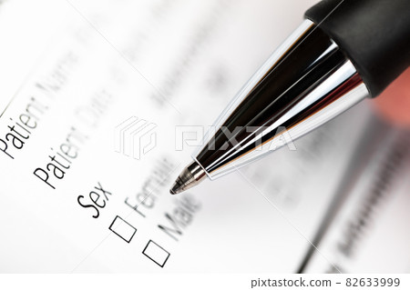 Hand with pen over gender option checkboxes in a form Hand with pen over gender option checkboxes in a form 82633999