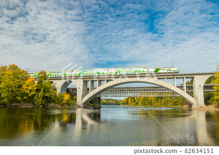 Kouvola, Finland - 25 September, 2019: Autumn landscape of bridge with moving passenger train and Kymijoki river waters in Finland, Kymenlaakso, Kouvola, Koria 82634151