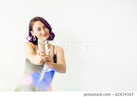 Happy new year. Festive woman. Holiday toast. Celebration fun. Pretty smiling lady black dress cheering glass of champagne holding bottle isolated white colorful light blur lens flare copy space. Happy new year. Festive woman. Holiday toast. Celebration fun. Pretty smiling lady black dress cheering glass of champagne holding bottle isolated white colorful light blur lens flare copy space. 82634167