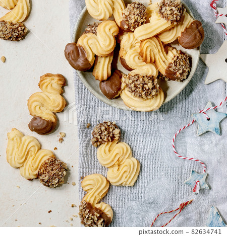 Shortcrust cookies with chocolate glaze and nuts over white. Christmas decorations. Top view Shortcrust cookies with chocolate glaze and nuts over white. Christmas decorations. Top view 82634741