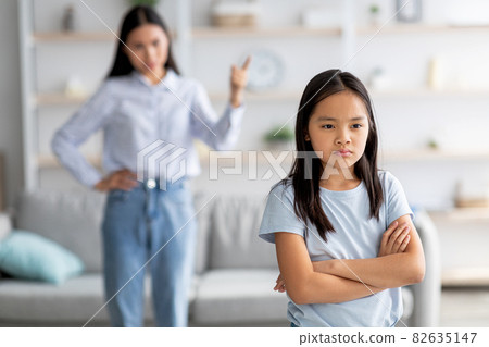 Family conflict. Mother and daughter quarreling at home, girl ignoring her mom, standing back to her with crossed arms 82635147