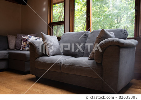 Sofa by the window illuminated by the sunlight of the forest 82635395