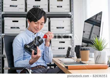 A male creator who maintains a digital SLR camera indoors A male creator who maintains a digital SLR camera indoors 82636351