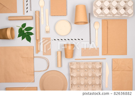 Set of different eco-friendly tableware and kraft paper food packaging on gray background. Street food paper packaging - cups, plates, straws, containers and paper bags. Mockup, flat lay Set of different eco-friendly tableware and kraft paper food packaging on gray background. Street food paper packaging - cups, plates, straws, containers and paper bags. Mockup, flat lay 82636882