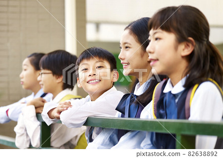 group of asian elementary school children with one boy looking at camera smiling group of asian elementary school children with one boy looking at camera smiling 82638892