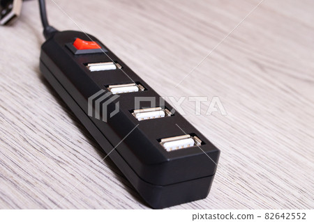 Black USB hub on a wooden background Black USB hub on a wooden background 82642552