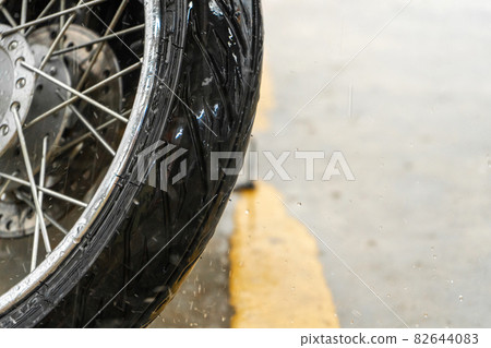 A close-up of the front wheel of a motorbike A close-up of the front wheel of a motorbike 82644083