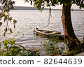 On the bow of the boat duck on the shore of the lake 82644639